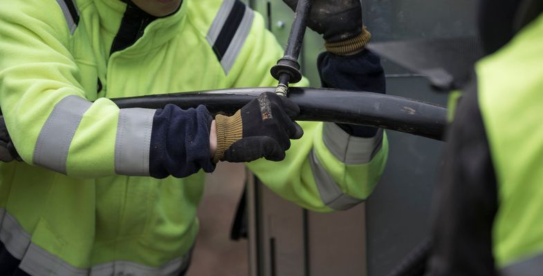 Installer using rip cord to open sheath on medium voltage cable