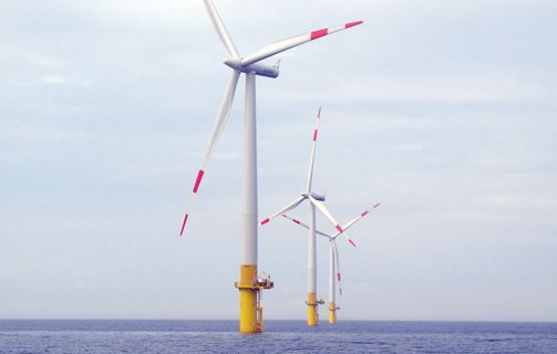 Three windmills at sea